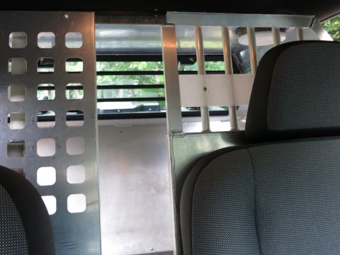 2001 Ford Crown Victoria - The interior of a vehicle shows a partition and bars separating the rear compartment from the outside.