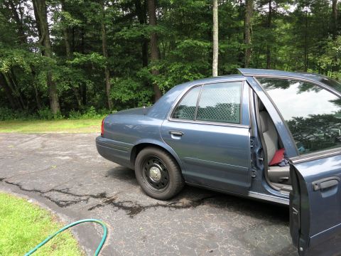 2001 Ford Crown Victoria - Blue 2001 Ford Crown Victoria parked on asphalt with trees in the background.