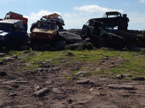 1988 Ford Bronco - Multiple off-road vehicles navigate a rocky landscape on a sunny day.