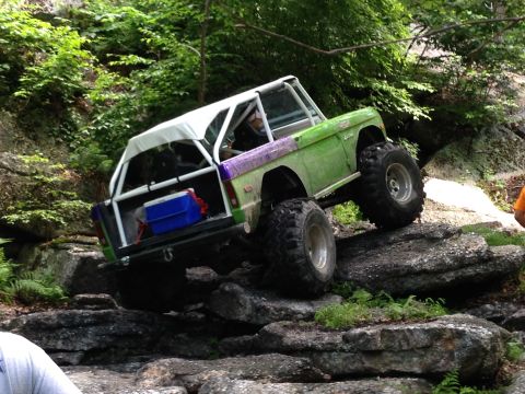 1988 Ford Bronco - Modified off-road vehicle navigating a rocky trail.