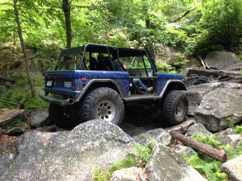 1988 Ford Bronco - This blue SUV navigates a rocky trail, its off-road capabilities.