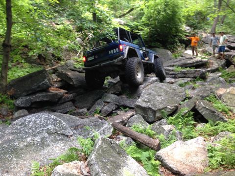 1988 Ford Bronco - A blue Ford Bronco tackles a challenging rocky off-road course.