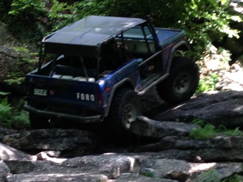 1988 Ford Bronco - This blue Ford Bronco is navigating a rocky trail with its top down.