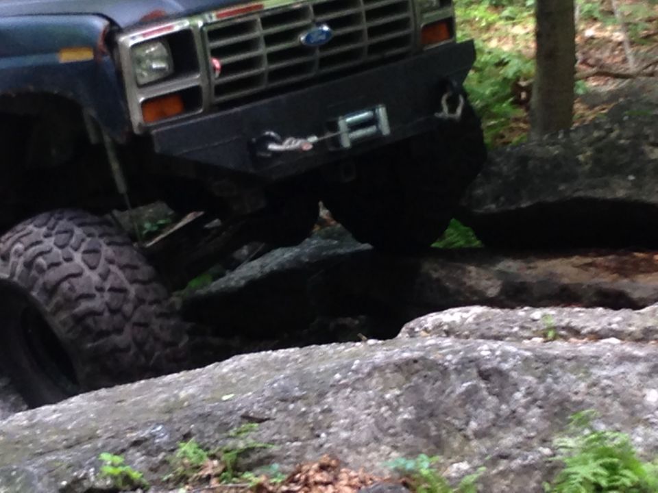 Ford Bronco with winch bumper navigating rocks on a trail