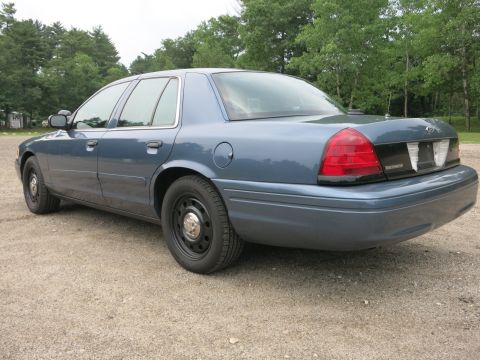 2001 Ford Crown Victoria - Rear quarter view of a blue 2001 Ford Crown Victoria with black steel wheels.