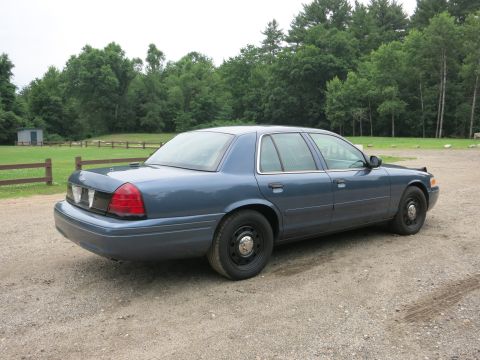 2001 Ford Crown Victoria - Side view of a blue 2001 Ford Crown Victoria sedan parked outdoors.