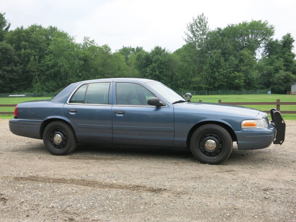Blue 2001 Ford Crown Victoria sedan with a push bar, seen from the side