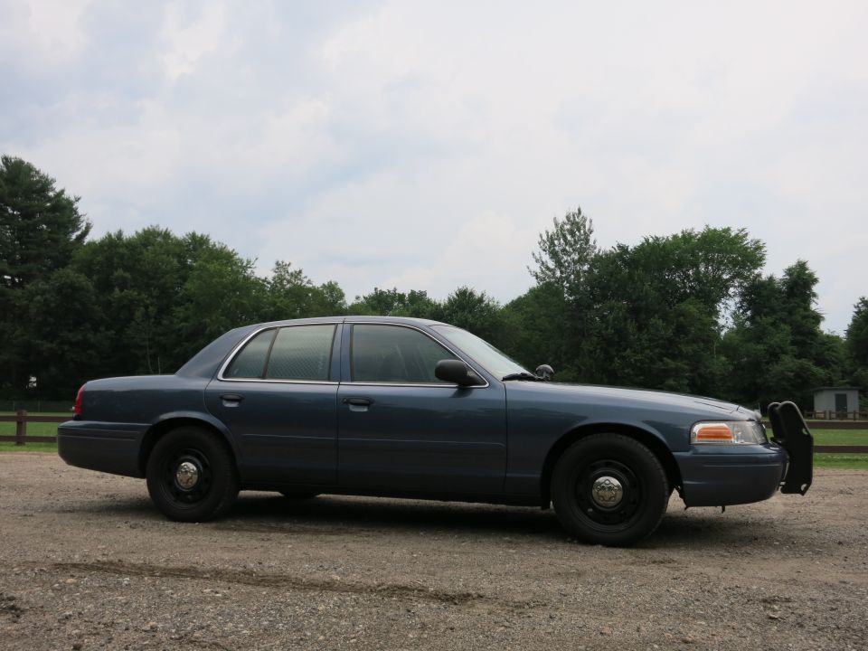 2001 Ford Crown Victoria police car, side view, dark blue paint, push bumper