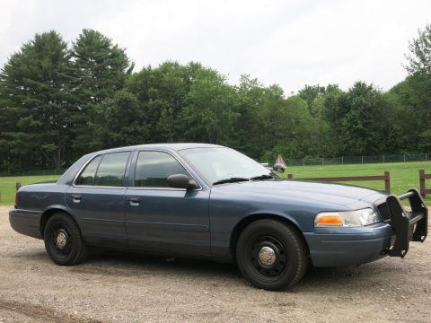 2001 Ford Crown Victoria - This 2001 Ford Crown Victoria police car features a push bumper and is seen from a three-quarter front perspective.