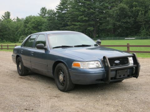 2001 Ford Crown Victoria - A blue 2001 Ford Crown Victoria is seen from a three-quarter front view, parked outdoors.