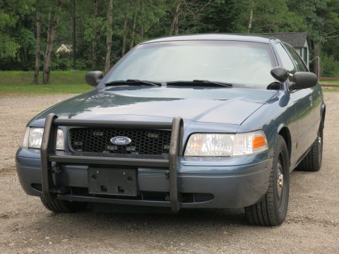 2001 Ford Crown Victoria - Front view of a blue 2001 Ford Crown Victoria police car equipped with a push bar.