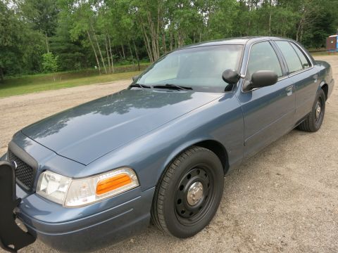 2001 Ford Crown Victoria - This 2001 Ford Crown Victoria, seen from a 3/4 front angle, features a push bar and appears to be a police or government vehicle.