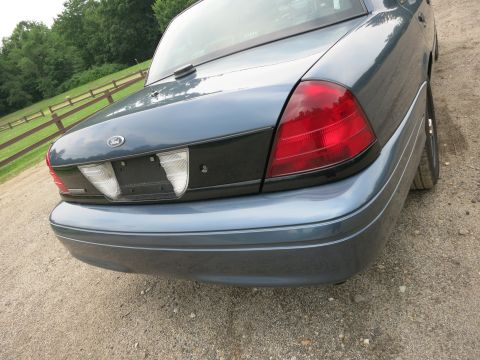 2001 Ford Crown Victoria - Rear view of a blue 2001 Ford Crown Victoria, showing its distinctive taillights and trunk lid.