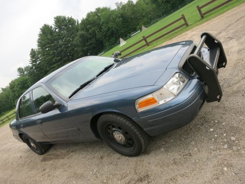 2001 Ford Crown Victoria - Front 3/4 view of a blue 2001 Ford Crown Victoria police car with a push bumper.