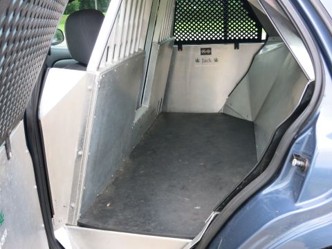2001 Ford Crown Victoria - Interior view of a blue vehicle modified with a metal partition and K-9 signage.