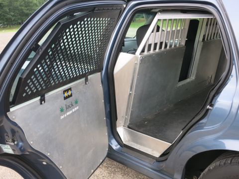 2001 Ford Crown Victoria - Interior view of a police vehicle modified for K-9 unit use, a protective cage and a memorial plaque.