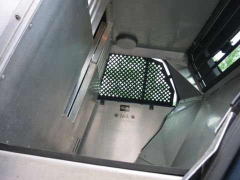 2001 Ford Crown Victoria - The interior of a vehicle compartment shows metal paneling and a grated opening to the outside.