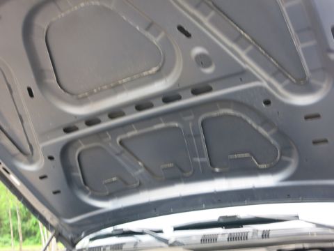 2001 Ford Crown Victoria - The underside of a car hood shows insulation panels and structural bracing, with windshield wipers visible beneath.
