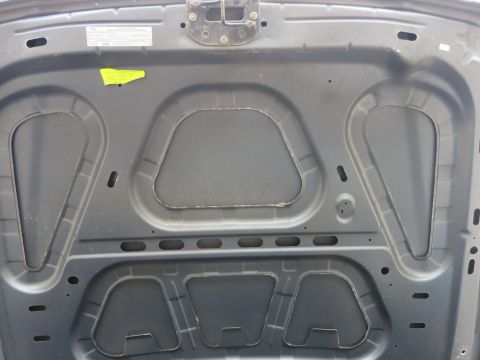 2001 Ford Crown Victoria - The underside of a car hood, showing insulation and structural bracing.