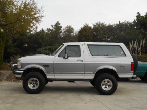 1994 Ford Bronco - Side view of a 1994 Ford Bronco, showing its two-tone paint scheme and lifted suspension.