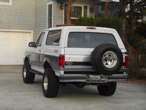 1994 Ford Bronco - Silver Ford Bronco parked in driveway with a house in the background.