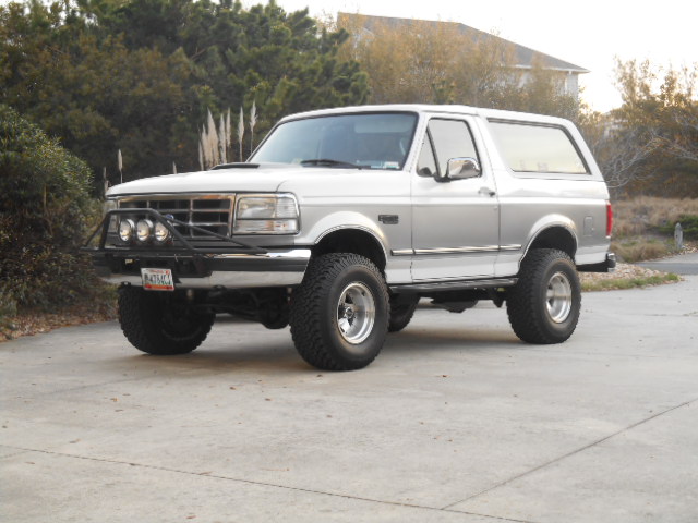 Silver SUV with custom front bumper and off-road tires parked on a driveway