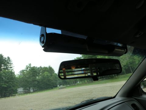 2001 Ford Crown Victoria - The interior of a vehicle shows a dashcam mounted above the rearview mirror.