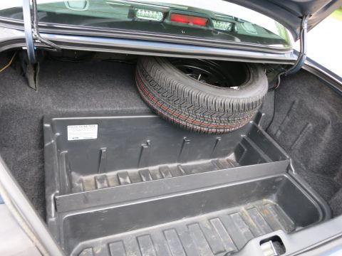 2001 Ford Crown Victoria - Trunk interior with spare tire and organizer tray. The tray has a label for 'POLICE TRUNK PACK'.