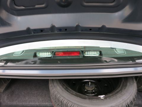 2001 Ford Crown Victoria - View inside the trunk of a car, showing the spare tire and the underside of the rear window.