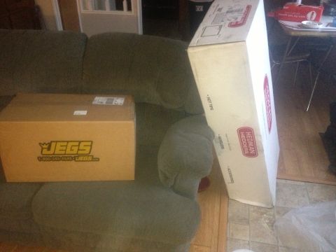 1970 Ford F-250 - Boxes containing automotive parts are placed on a couch in a living room.