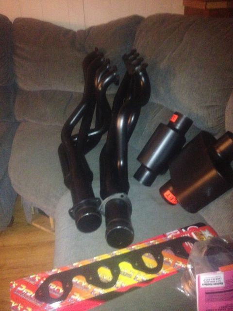 1970 Ford F-250 - Exhaust system parts, including headers and mufflers, are laid out on a couch.