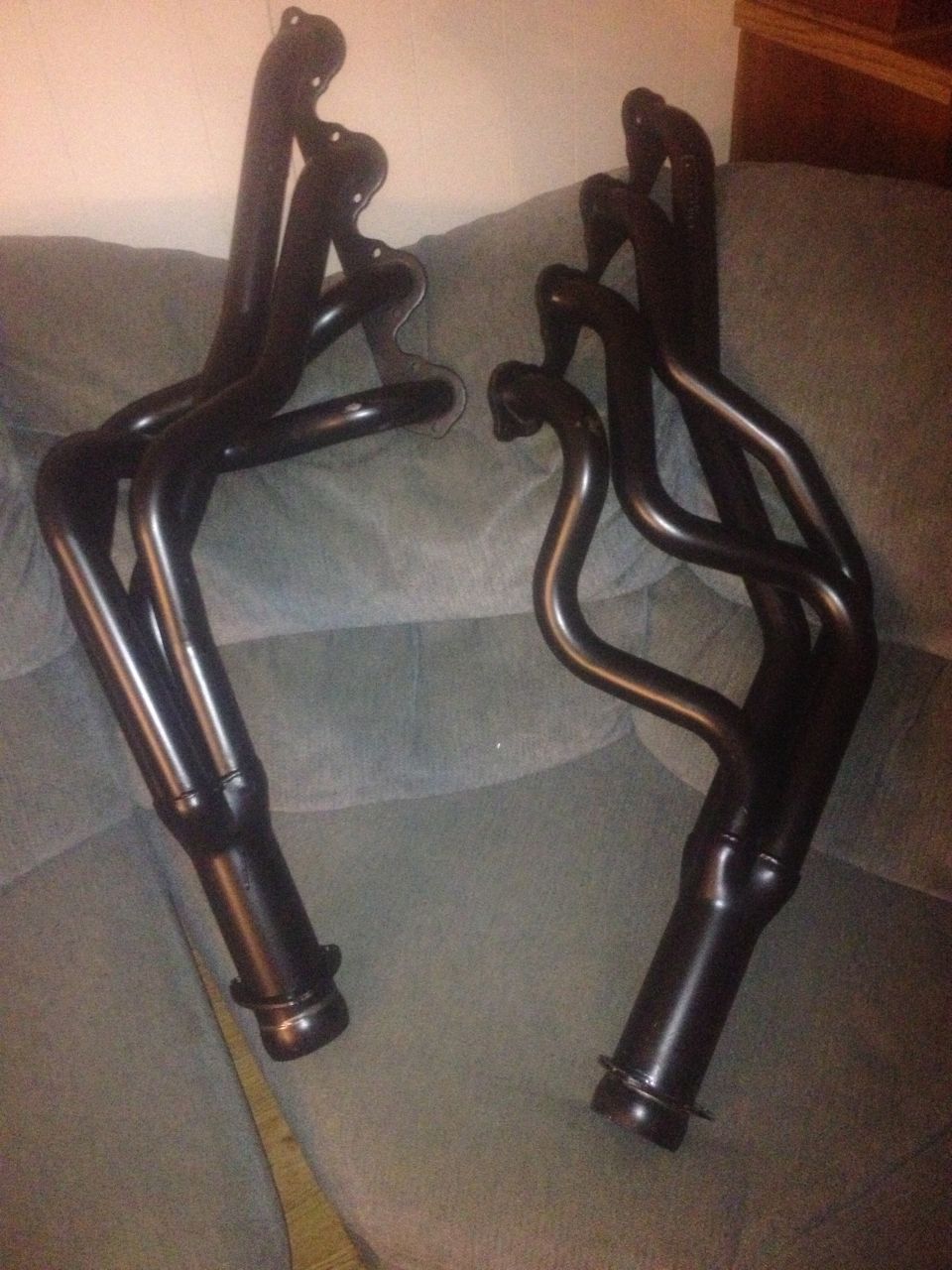 Pair of black exhaust headers on a couch