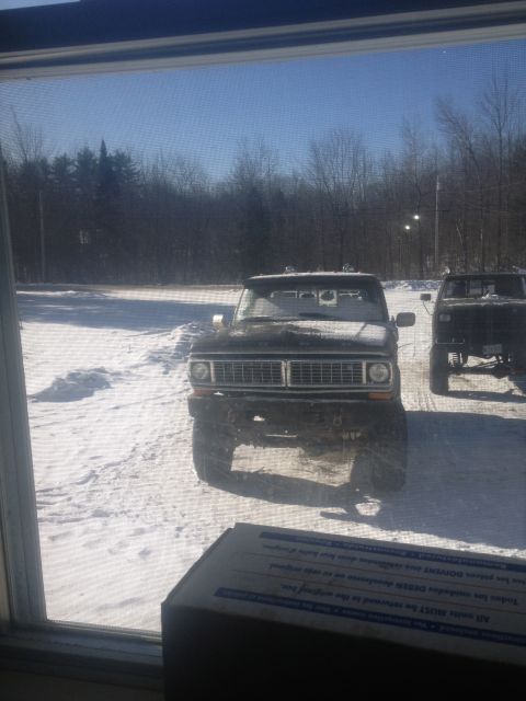 1970 Ford F-250 - A black 1970 Ford F-250 sits in the snow, with another truck visible in the background.