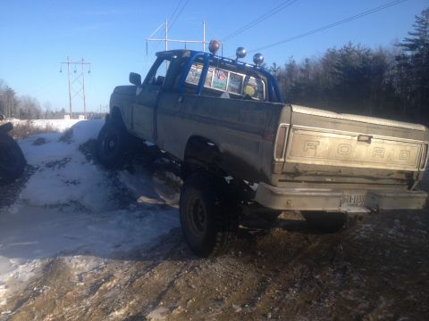 1970 Ford F-250 - This modified Ford pickup truck is shown off-roading in a snowy and muddy environment.
