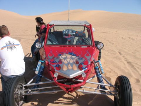 1993 Ford Taurus - A red dune buggy with flame graphics is parked in the sand dunes on a sunny day.