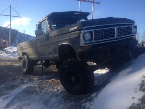1970 Ford F-250 - This lifted Ford pickup truck is parked on a snowy incline under a clear blue sky.
