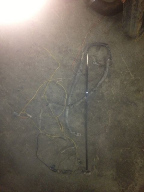 1970 Ford F-250 - A disassembled wiring harness lies on a concrete floor, with various colored wires and protective sheathing visible.