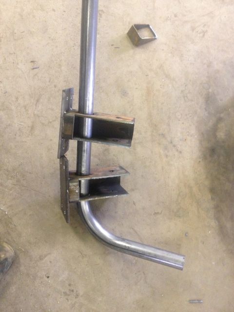 1970 Ford F-250 - Metal pipe assembly with brackets and a bent pipe section is shown on a concrete floor.
