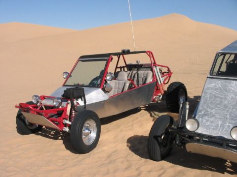 1993 Ford Taurus - Two dune buggies are parked on a sandy desert landscape with dunes in the background.