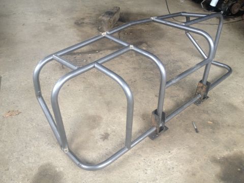 1970 Ford F-250 - A fabricated metal roll cage structure sits on a concrete floor, ready for installation.