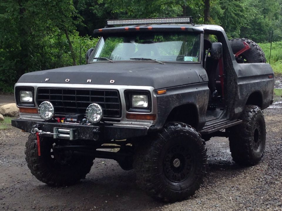 Modified Ford Bronco with off-road tires, winch, and light bar