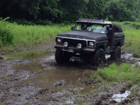 1979 Ford Bronco - This 1979 Ford Bronco navigates a muddy trail with its off-road modifications.