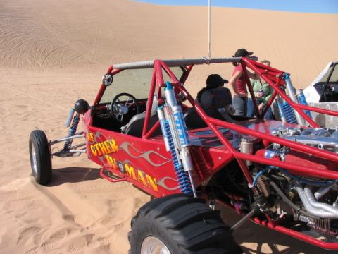1993 Ford Taurus - A red dune buggy with flame decals and the text 'The Other Woman' is seen in the sand dunes.