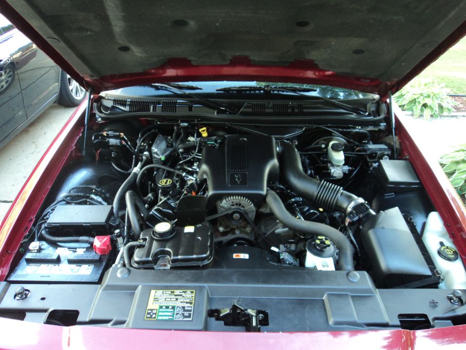 2004 Mercury Grand Marquis engine bay with hood open. Shows engine, battery, and air intake