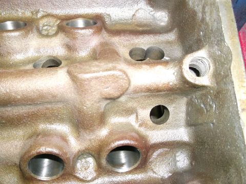 1963 Ford Galaxie - Close-up view of an engine block casting, showing machined surfaces and bolt holes. The Supermotors.net logo is visible in the lower right…