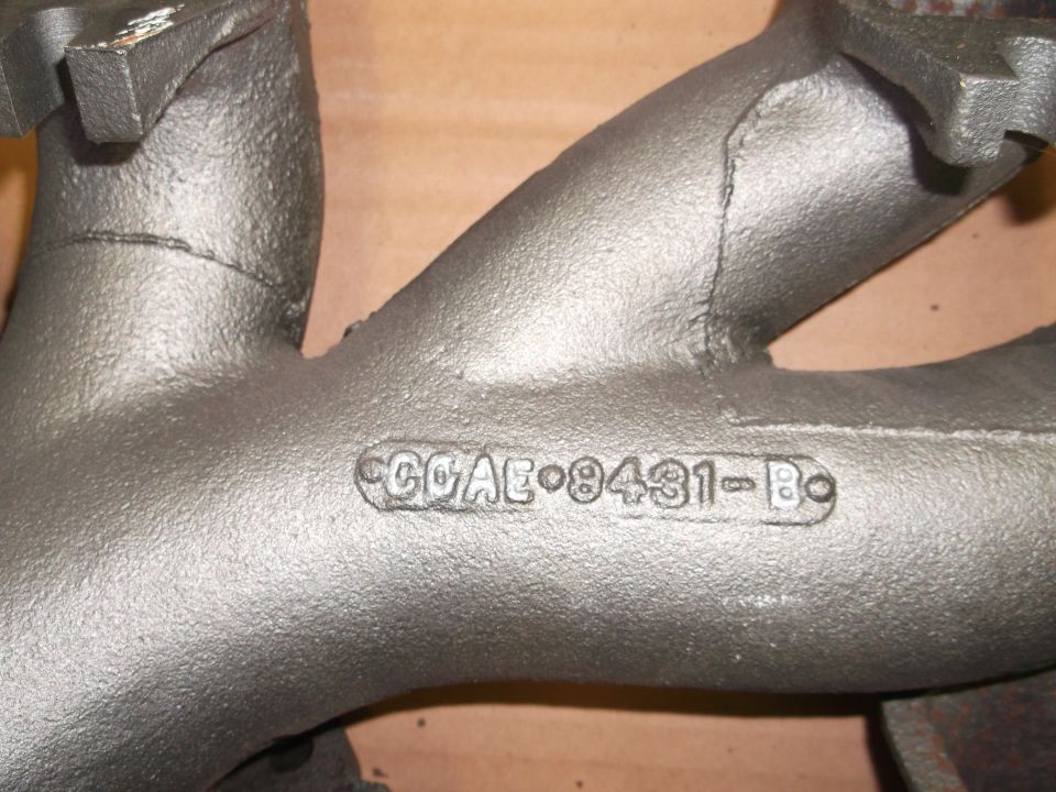 Gray cast iron exhaust manifold with "C6AE-9431-B" stamped on it