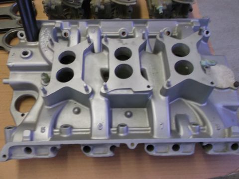 1963 Ford Galaxie - Close-up of an aluminum intake manifold, likely for a performance engine, with four distinct mounting areas for carburetors.