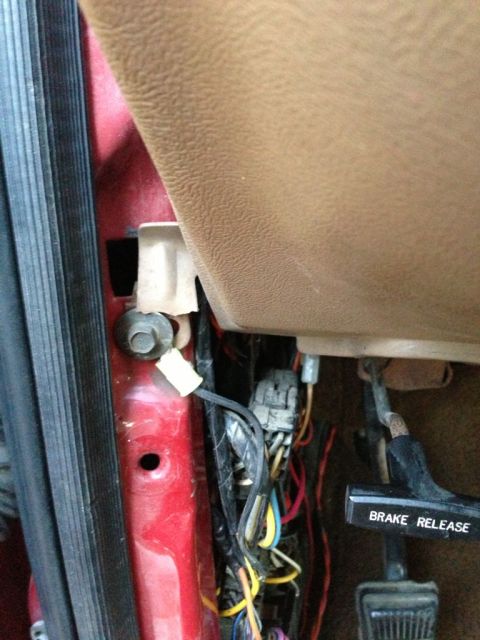 1989 Ford Bronco - The brake release lever is visible along with a bundle of wires and connectors inside the vehicle's interior.