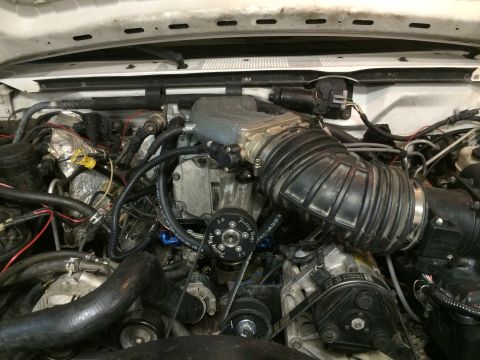 1996 Ford Bronco - Close-up view of a vehicle's engine bay, highlighting a supercharger and associated components.