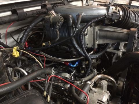 1996 Ford Bronco - Close-up view of a vehicle's engine compartment, highlighting a supercharger and associated components.